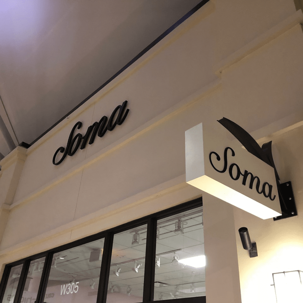 Storefront with "Soma" signage and lighting.